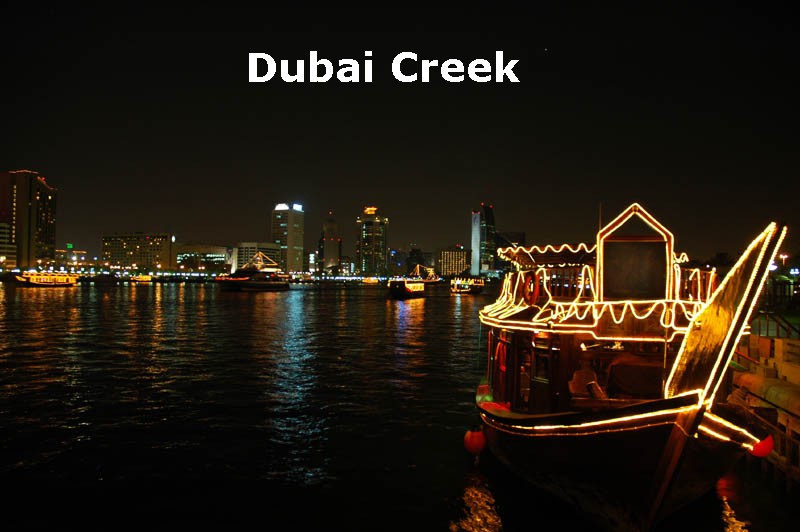 Dubai Creek night view where lighted boats are floating on water.